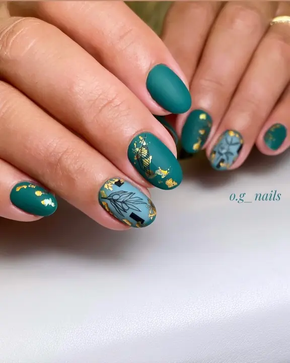 Matte teal manicure with gold leaf and botanical accents