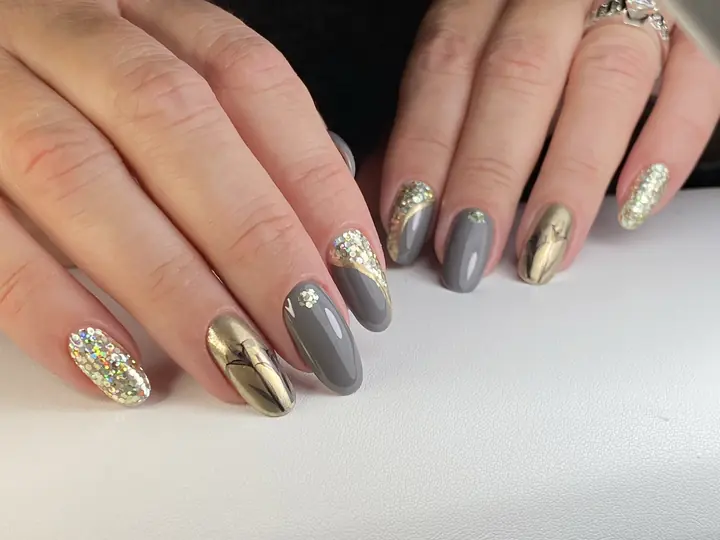 Grey and metallic gold manicure with glitter accent