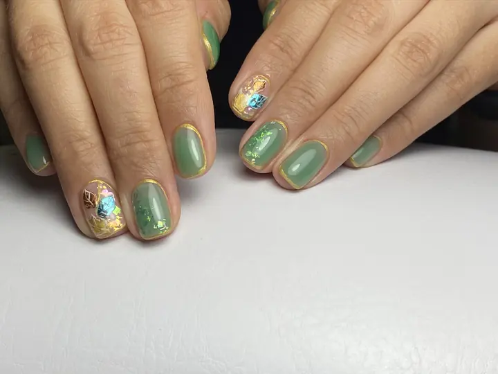 Sage green manicure with gold foil accents