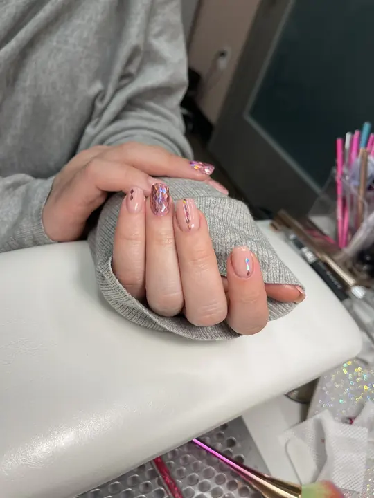 Subtle nude manicure with a glitter accent