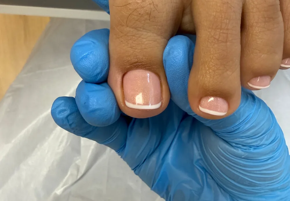 Natural French gel pedicure with neatly shaped toenails